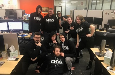 Photo of students in CASS t-shirts in office
